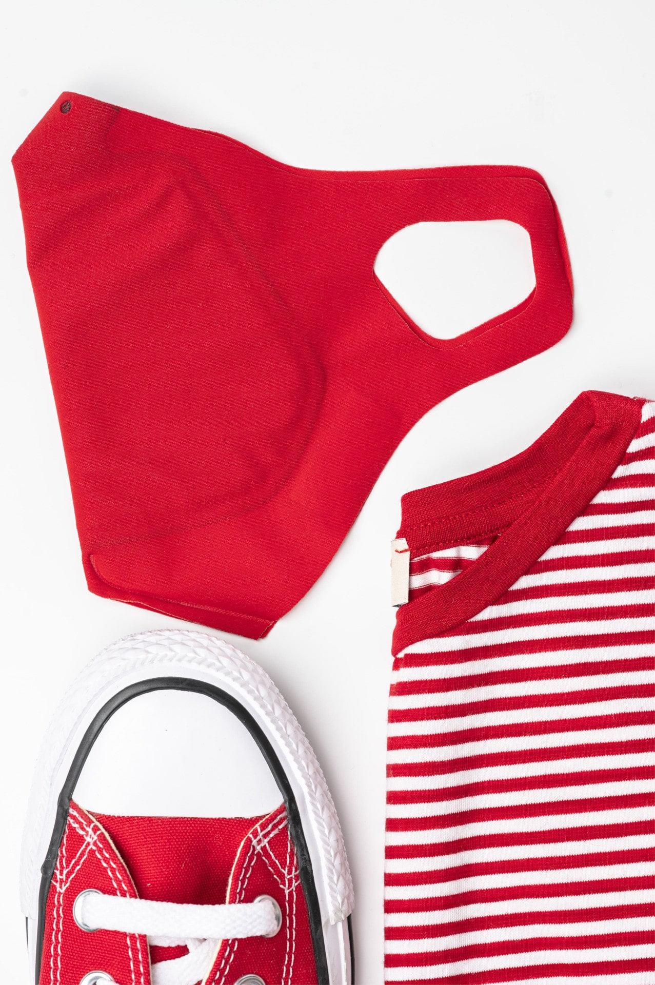 Rote Schutzmaske in Kombination mit rot-weiß kariertem T-Shirt und Sneaker